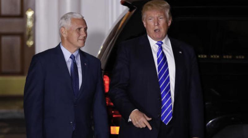 President-elect Donald Trump pauses to talk to media as he walks with Vice President-elect Mike Pence to board his motorcade vehicle at Trump National Golf Club Bedminster clubhouse in Bedminster, N.J. (Photo: AP)