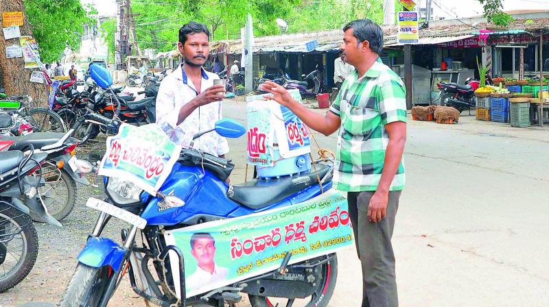 Gas stove mechanic of Guntur city J. Rajamohan quenching thirst of the public during scorching summer through cool mineral water turning his bike into mobile water kiosk at Guntur. (Photo: DC)