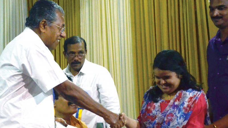 A differently-abled child greets Chief Minister Pinarayi Vijayan during the  launch of work books and teacher notes prepared by State Council for Education Research and Training (SCERT) in Thiruvananthapuram on Monday. (Photo: DC)