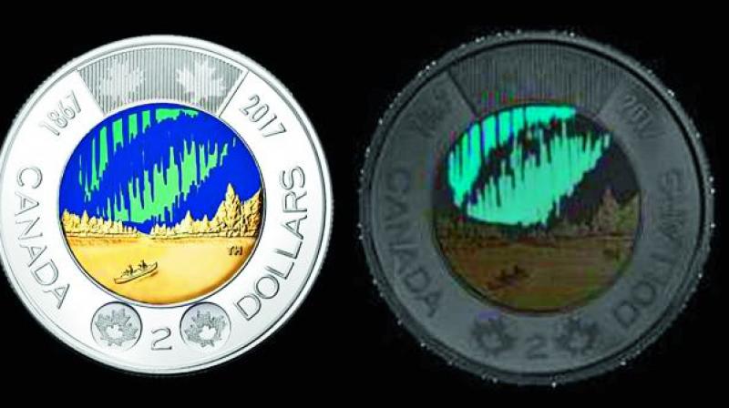 In the daylight, the northern lights on the coin appear blue and green. But in the dark, they glow. The coin was designed by Timothy Hsia, a doctor from British Columbia, who was inspired by the design contests theme.