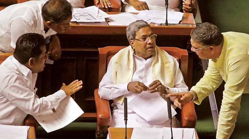 Chief Minister Siddaramaiah in conversation with Primary and Secondary Education Minister Tanveer Sait and others during the Assembly session in Bengaluru on Tuesday 	(Photo:DC)