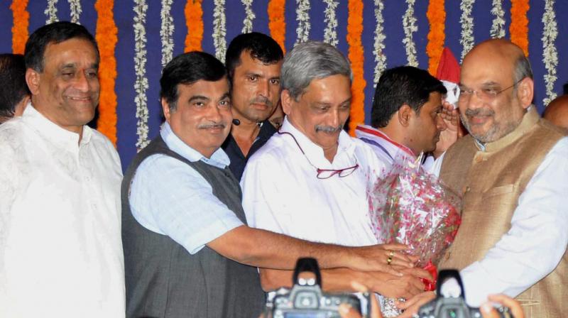 Newly sworn-in Goa Chief Minister Manohar Parrikar being greeted by BJP President Amit Shah and Union minister Nitin Gadkari after his oath at a ceremony in Panaji. (Photo: PTI)