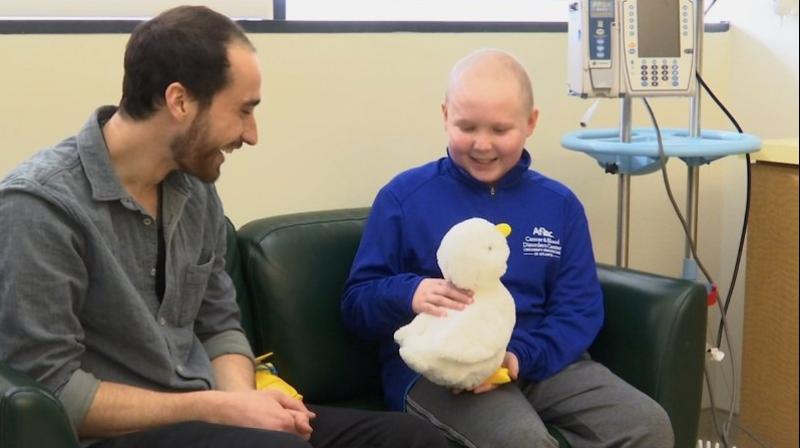 A 12-year-old cancer patient Ethan Daniels at medical facility in Atlanta speaks with Aaron Horowitz, co-founder and CEO of Sproutel, who designed â€œMy Special Aflac Duckâ€ to promote emotional well-being by helping children living with cancer develop a sense of control and manage stress through interactive technology. (Image: AP)