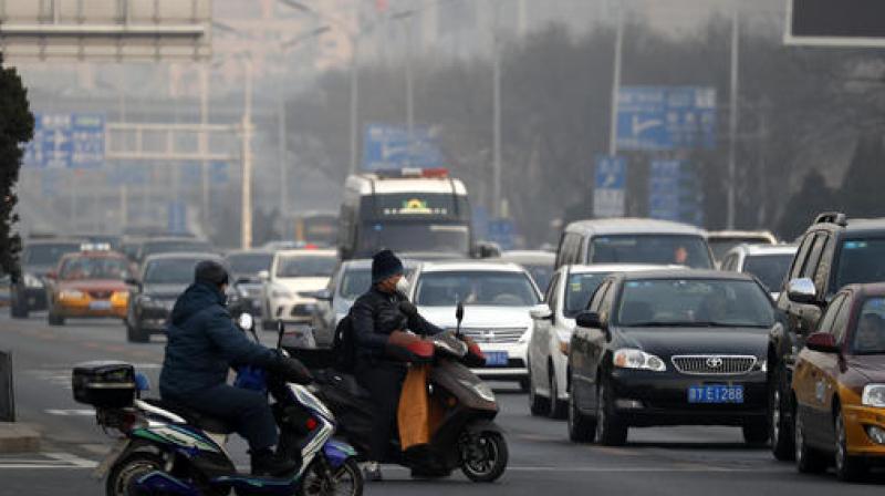 State media reported on Monday that more than 700 companies stopped production in Beijing, and that traffic police were restricting drivers by monitoring their license plate numbers. (Photo: AP)