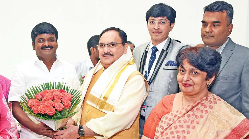 Health  minister  C. Vijayabaskar presents a bouquet to Union minister Jagat Prakash Nadda in New Delhi on Friday. (Photo:DC)