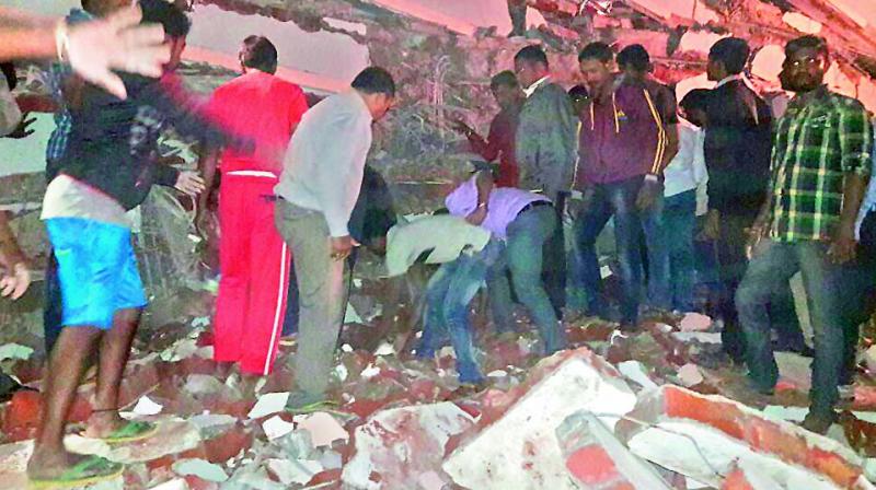 Locals and rescue workers search for bodies feared buried under the debris of a collapsed five-storey building at Nanakramguda on Thursday. (Photo: DC)
