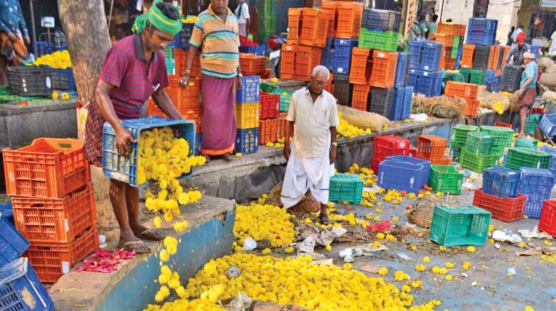 Unsold flowers being dumped by flower traders at Koyambedu market. (Photo: DC)