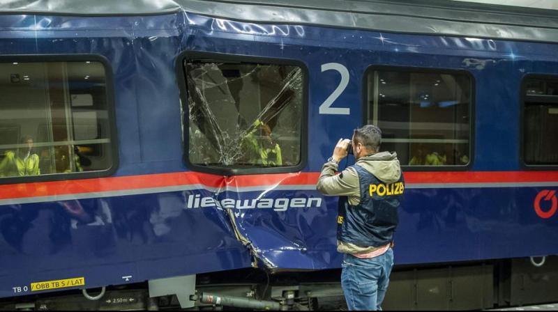 A policemen takes pictures of a demolished couchette car standing on a platform after two train carriages collided at the main railway station in Salzburg. (Photo: AFP
