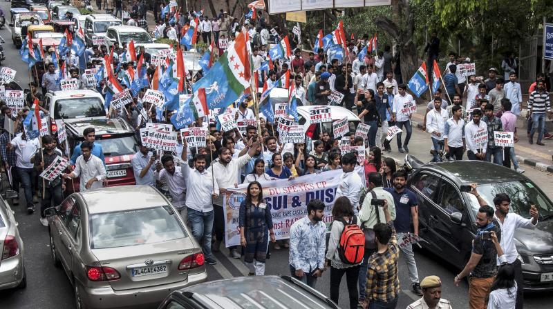 NSUI and DUSU activists display placards and shout slogans during a protest march against rape cases, atrocities against women and various other issues, in North Campus, Delhi University (Photo: PTI)