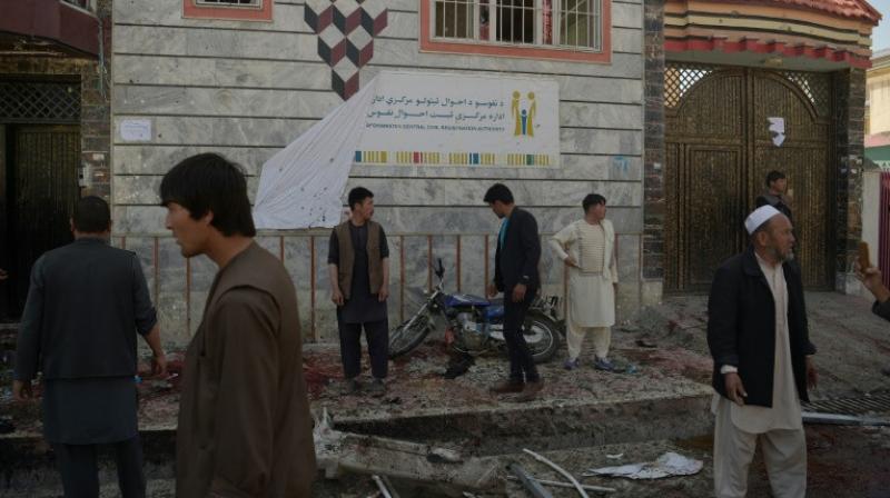 Residents inspect the site of a suicide bombing outside the voter registration centre. (Photo: AFP)
