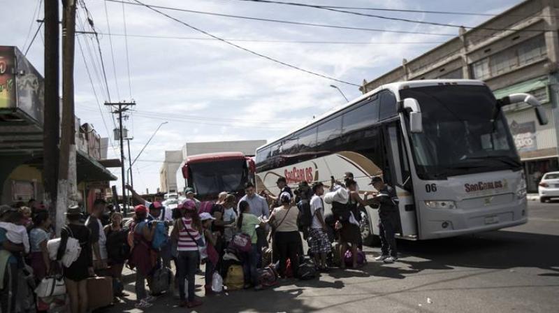 Migrants in a caravan of Central American asylum-seekers board buses in Mexicali, Mexico, Thursday, April 26, 2018, for a two-hour drive to Tijuana to join up with about 175 others who already arrived. (Photo: AP)