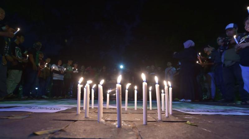 Lit candles are placed in the ground during a candlelight vigil in support of the victims and their relatives following a series of bomb attacks in Surabaya, in Jakarta on May 14, 2018. (AFP Photo)