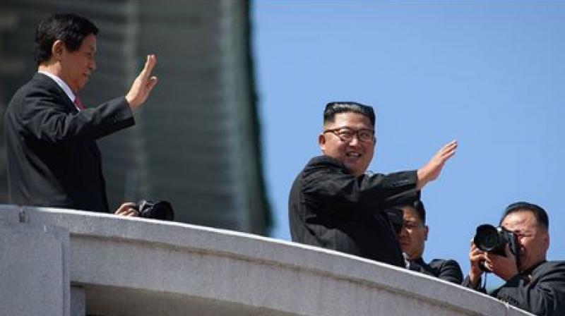 Kim Jong Un showed off his friendship with China, raising the hand of President Xi Jinpings envoy as they saluted the crowd together afterwards (Photo: AFP)