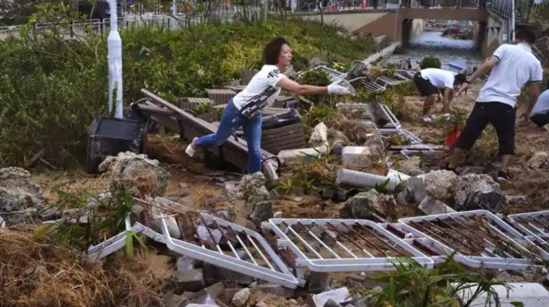 People clean up debris caused by Typhoon Mangkhut outside a housing estate on the waterfront in Hong Kong on Monday. (Photo:  AP)