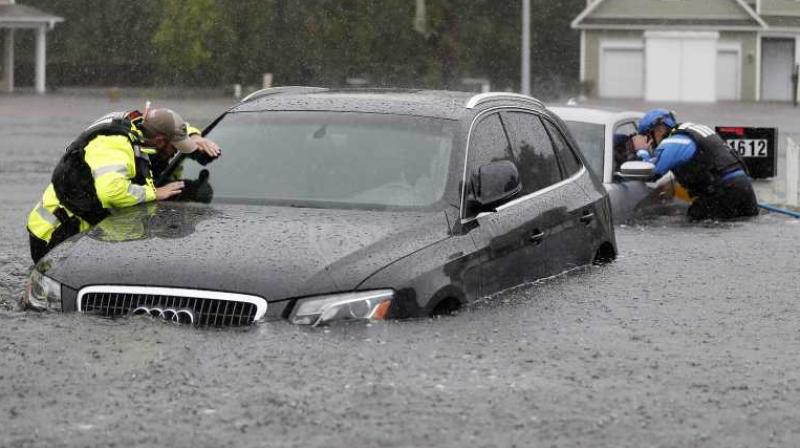 Members of the North Carolina Task Force urban search and rescue team check cars in a flooded neighborhood looking for residents who stayed behind as Florence continues to dump heavy rain in NC. (Photo: AP)