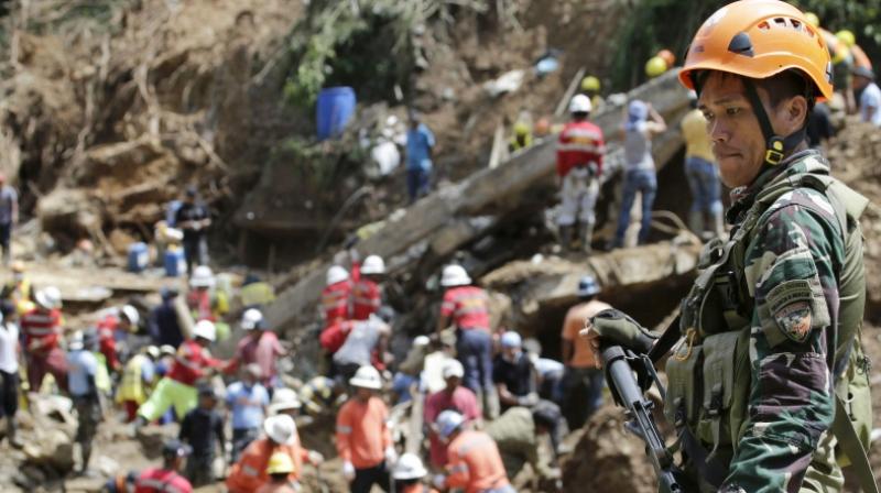 A Filipino trooper keeps guard as search operations continue at the site where victims are believed to have been buried by a landslide triggered by Typhoon Mangkhut lashed across Itogon, Benguet province, northern Philippines. (Photo: AP)