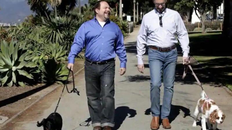 Steven May (right) walks with his dog, Winnie, beside his attorney, David Pisarra, with his dog, Dudley in Santa Monica, California. (Photo: AP)