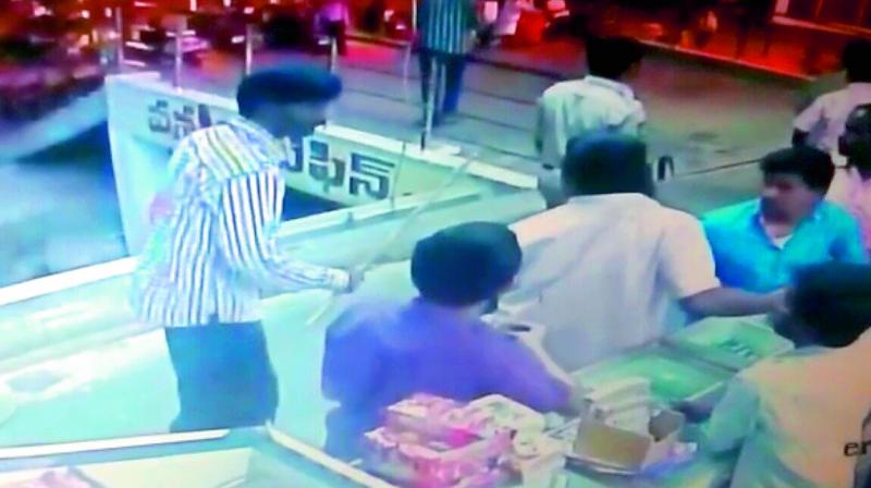 A CCTV grab shows Meerpet SI Venkataiah (in plain clothes) threatening people.