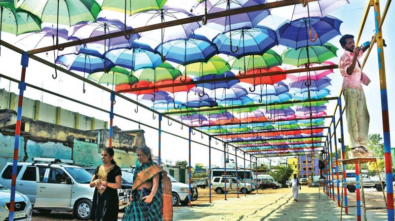 Visitors walk under the new umbrella roof towards the Meenakshi Amman temple entrance from the parking lot at Madurai on Wednesday.	(Photo: DC)