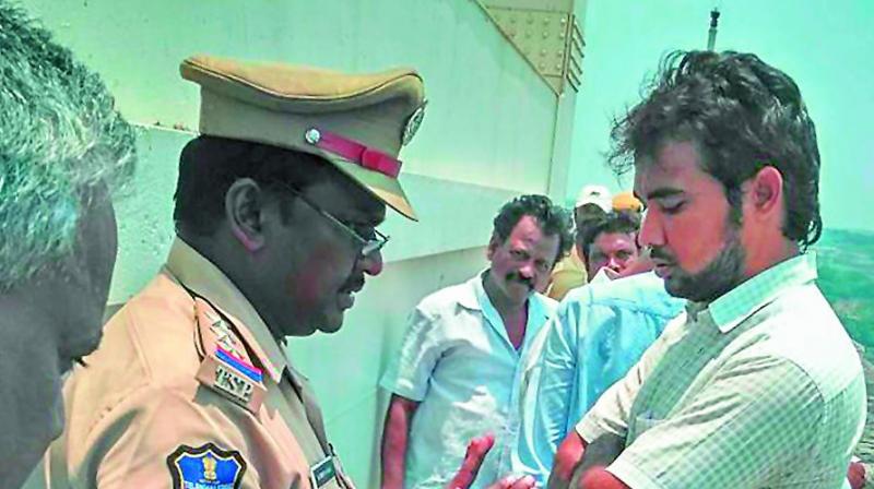 A cop tries to cool frayed tempers at Nagarjunasagar dam on Monday. (Photo: Deccan chronicle)