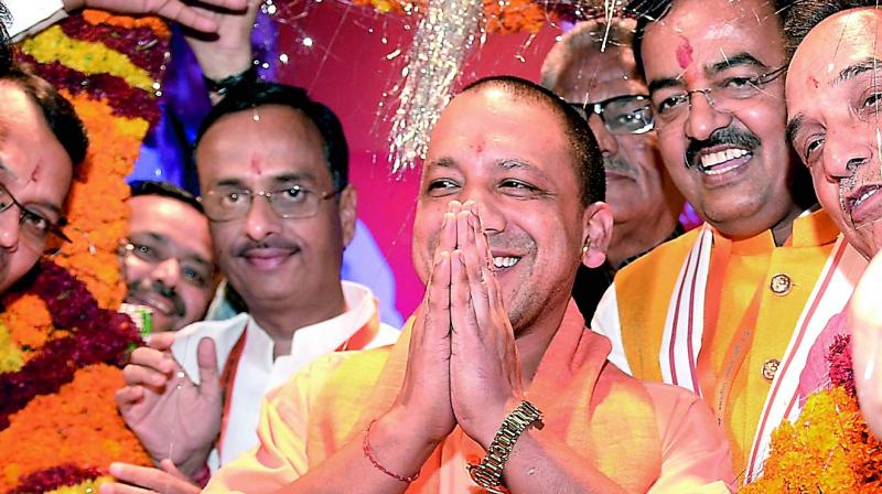 UP C.M. Yogi Aditiyanath being welcomed by party workers in Lucknow on Monday. (Photo: PTI)