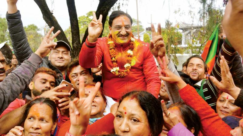 Senior BJP leader Ramesh Pokhariyal Nishank celebrates with party workers after the declaration of assembly election results in Dehradun on Saturday. (Photo: PTI)