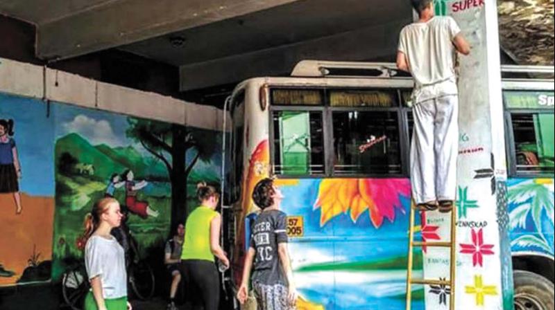 Norwegian tourists paint the walls of Palayam bus stand as part of anti-drug campaign. DC FILE
