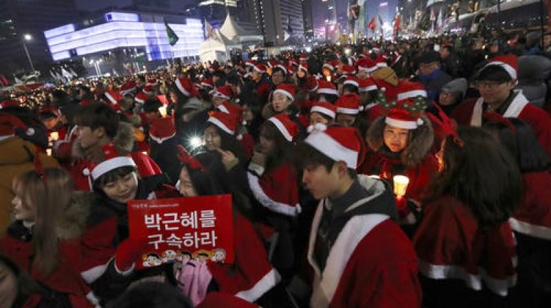 Despite sub-zero temperatures, protesters waved banners and balloons, and sang along to Christmas songs with new lyrics heaping ridicule on Park and calling for her immediate removal. (Photo: AP)