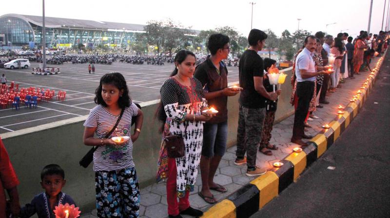 Staff of Thiruvananthapuram airport and their and family members stage a candle light vigil in front of the international terminal in protest against the privatisation of the airport on Wednesday.  (DC)