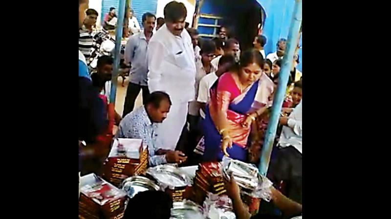 Former Bengaluru deputy mayor R Shankar and his wife distributing saris among voters of Ranibennur. (Photo: DC)