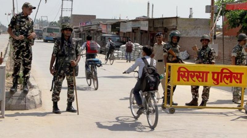 Security forces stand guard at Satnam Chowk, the main entrance to the Dera Sacha Sauda headquarters, in Sirsa district of Haryana. (Photo: PTI)