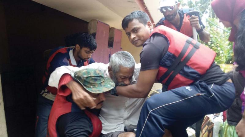 Navy personnel lift an old man from a flood hit house in Wayanad which experienced unusually heavy rains this monsoon on Saturday. More rains are predicted in Wayanad and Idukki districts till August 14. (Photo: Navy)