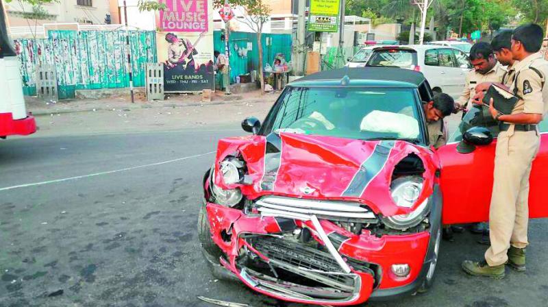 Policemen examine a Mini Cooper that was damaged in an accident at Neerus Junction, Jubilee Hills. The car, belonging to one Gopi, was taking a U-turn at the junction when an SUV rammed into it. No one was injured.