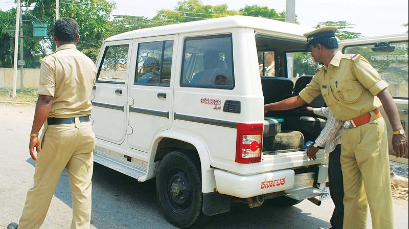 Police check a government vehicle at an election check post near Gundlupet on Wednesday. (Photo: KPN)