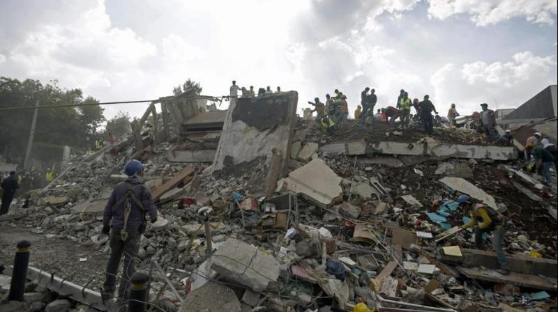Rescuers, firefighters, policemen, soldiers and volunteers remove rubble and debris from a flattened building in search of survivors after a powerful quake in Mexico City on September 19, 2017. (Photo: AFP)