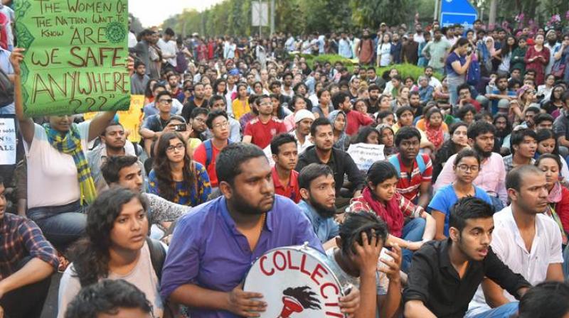JNU students raise slogans over the issue of compulsory attendance at a protest in New Delhi on Friday. (Photo: PTI)