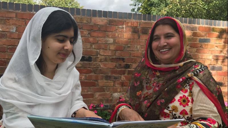 In this picture, Malala Yousafzai is sitting with her mother Toor Pekai reading her new book Malalas Magic Pencil. (Photo: Twitter / Malala Yousafza)
