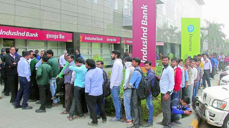 People queue up outside a bank to withdraw cash in Gurugram on Wednesday. (Photo: PTI)