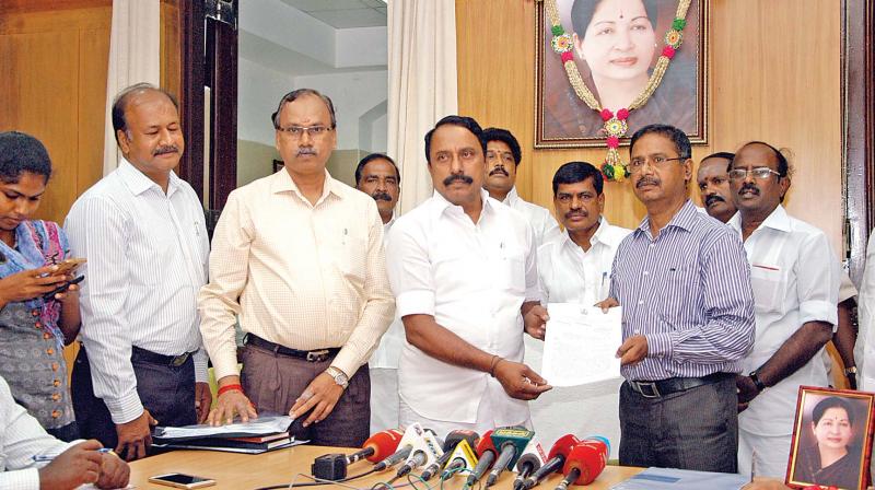 Chennai district chief educational officer Manoharan receives the plus-1 model question paper from school education minister K.A. Sengottaiyan at an event in Chennai on Friday. SCERT director G.Arivoli and others are also seen. (Photo: DC)