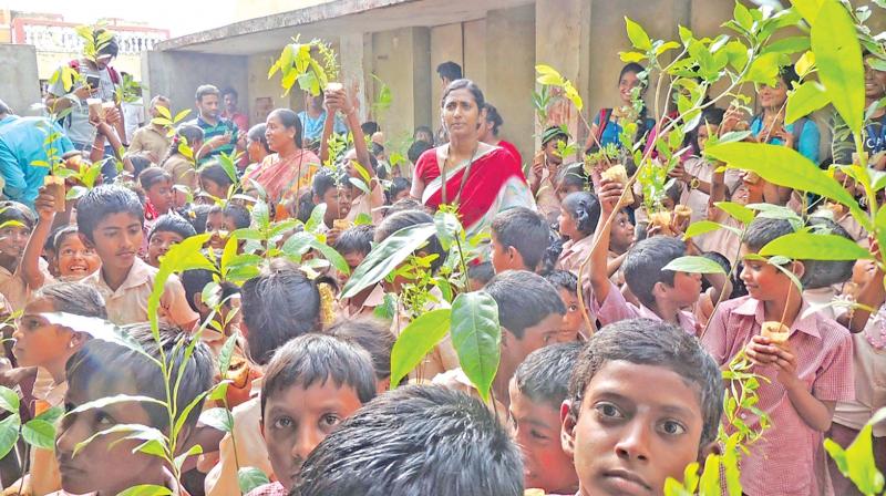School students pose with fruit bearing saplings at a function held in Vellore by VIT Nature Club. (Photo: DC)