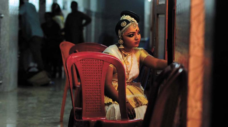 A mohiniyattam dancer watchers her competitors performing.