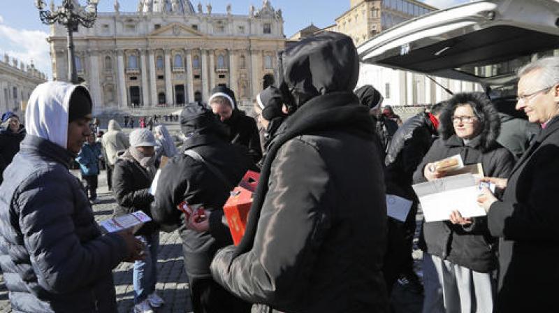 Nuns distribute food and drinks to needy people in St. Peters square at the Vatican. (Photo: AP)