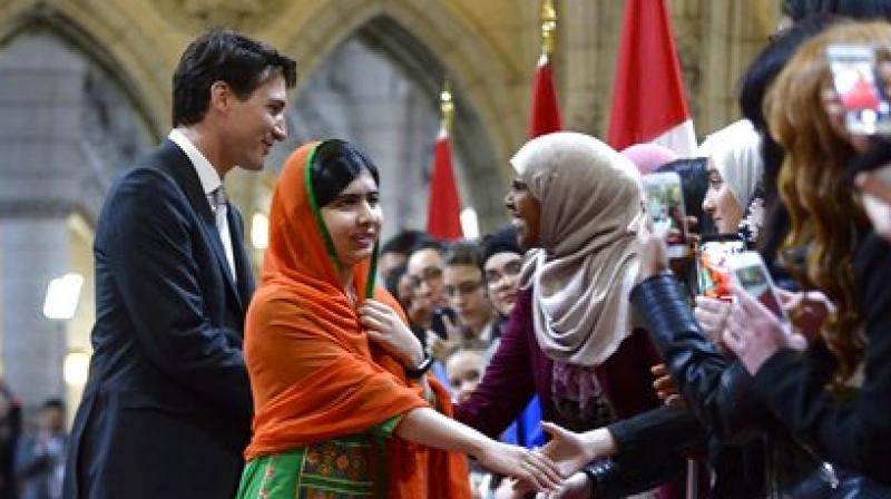Pakistani activist and Nobel Peace Prize winner Malala Yousafzai, center, greets fans after walking through the hall of honour with Prime Minister Justin Trudeau. (Photo: AP)