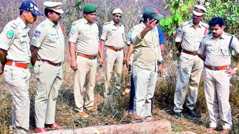 Police superintendent Vishnu S. Warrier seizes teakwood logs that were hidden in the bushes by the smugglers on the outskirts of Jogipet village in Sirikonda mandal in Adilabad district. (Photo:  DC)