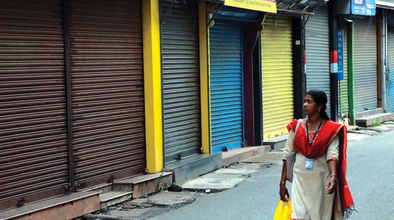 A woman passes through the deserted Broadway, a busy shopping street on normal days. Most  shops in Broadway remained closed as part of the statewide shutdown strike called by Kerala Vyapari Vyavasayi Ekopana Samithi (KVVES) on Tuesday. 	(Photo: ARUN CHANDRABOSE)