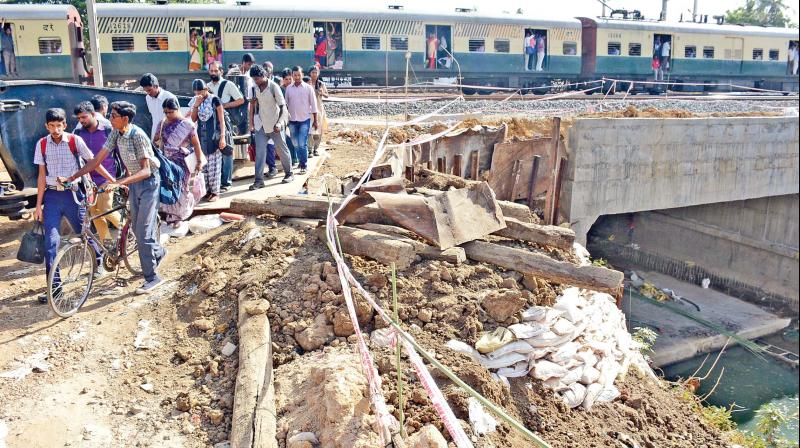 Students are forced to cross railway tracks near Korattur railway station, due to delay in subway work.	(Photo: DC)