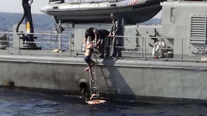 In this photo provided by the Croatian Defence Ministry, a woman who identified herself as Kay from England, climbs aboard a Croatian Coast Guard ship some 90 kilometres from the Croatian coast. (Photo: AP)