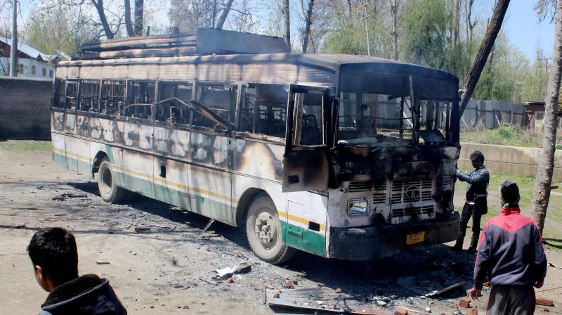 A charred polling staff bus following an attack by a group of protesters at Nowgam during voting for Srinagar bypoll. (Photo: PTI)