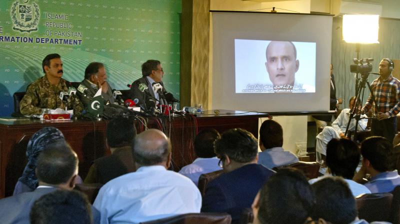 Journalists look a image of Indian naval officer Kulbhushan Jadhav, who was arrested in March 2016, during a press conference by Pakistans army spokesman and the Information Minister, in Islamabad, Pakistan. (Photo: AP)
