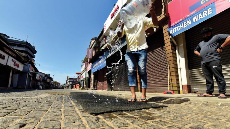A shopkeeper cleans the carpet at SM Street. (Photo: DC)